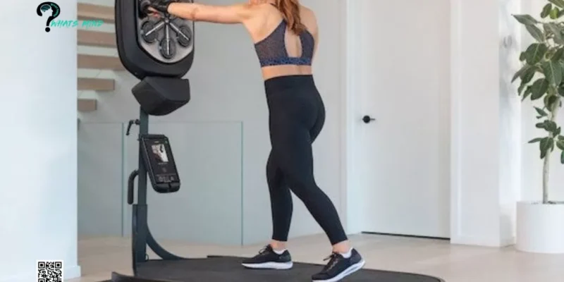 A woman is standing on a treadmill in a liteboxer fitness bundle in a living room.