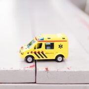 A toy ambulance sits on top of a table.