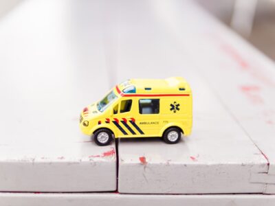 A toy ambulance sits on top of a table.