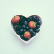 A bowl of berries in the shape of a heart.