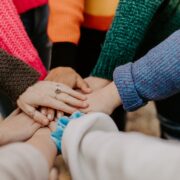 A group of people putting their hands together in a circle.