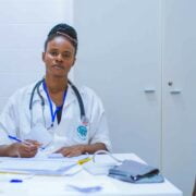 A female doctor sitting at a table with a patient.