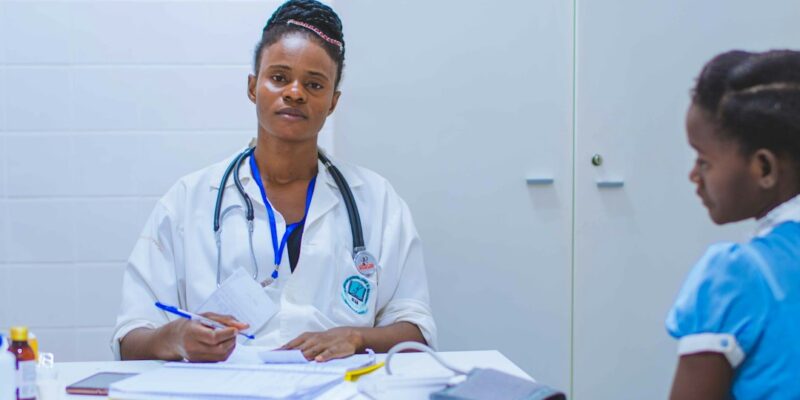 A female doctor sitting at a table with a patient.