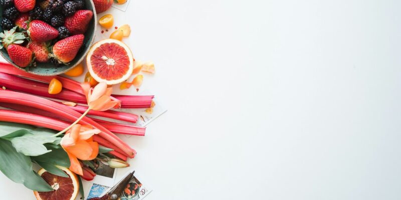 A bowl of fruits and vegetables on a white background.