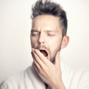 A man in a white bathrobe with his mouth open.