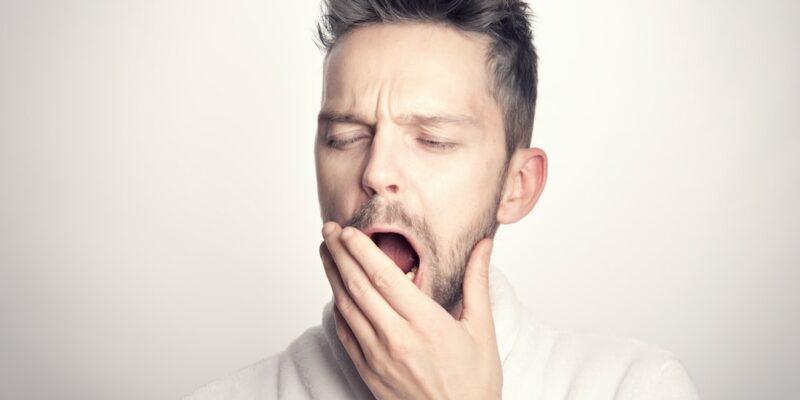 A man in a white bathrobe with his mouth open.