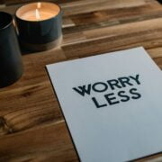 A piece of paper with the word worry less on it on a wooden table.