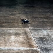 A person laying on a concrete floor.