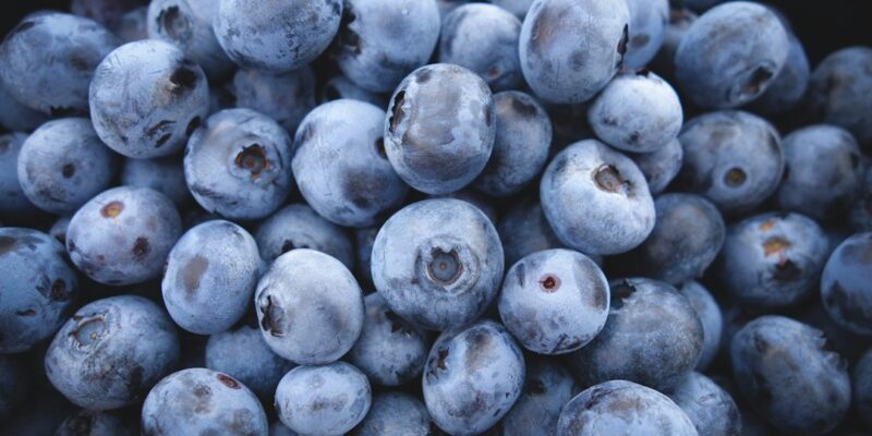 A pile of blueberries on a black background.