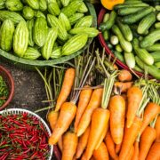 A variety of vegetables in bowls on a table.