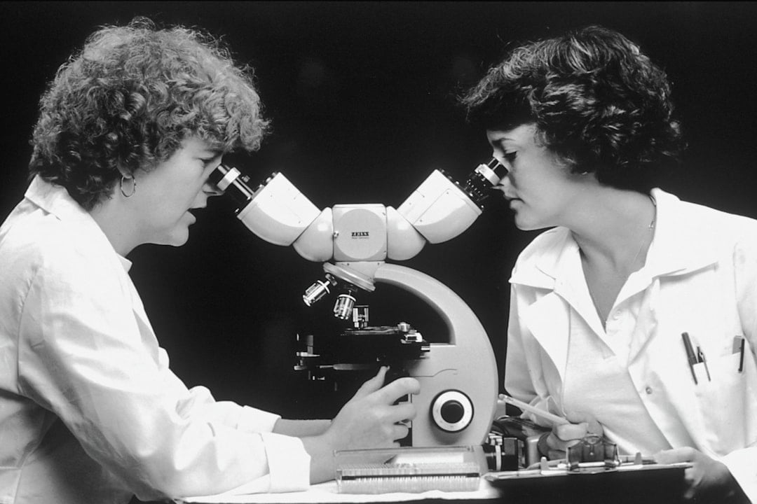 Women looking through a microscope.