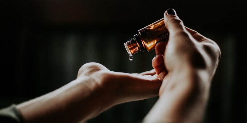 A woman's hand holding an essential oil bottle.