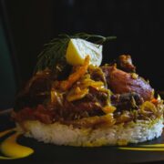 A plate of rice with chicken on top of it.