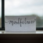A piece of paper with the word mindfulness sitting on a window sill.