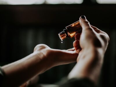 A woman's hand holding an essential oil bottle.