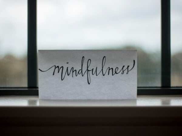 A piece of paper with the word mindfulness sitting on a window sill.