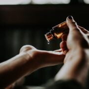 A woman's hand holding an essential oil bottle.