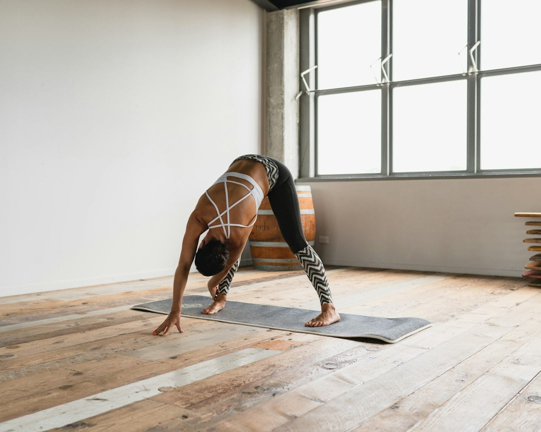 A woman stretching on a mat in a room.