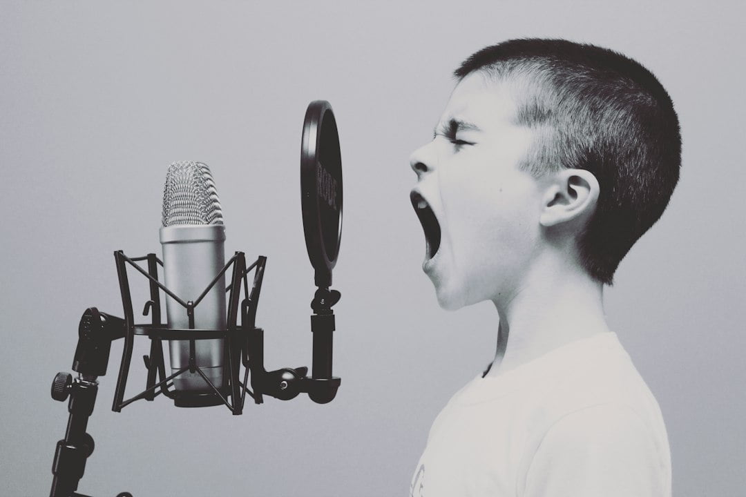 A boy is yelling into a microphone.