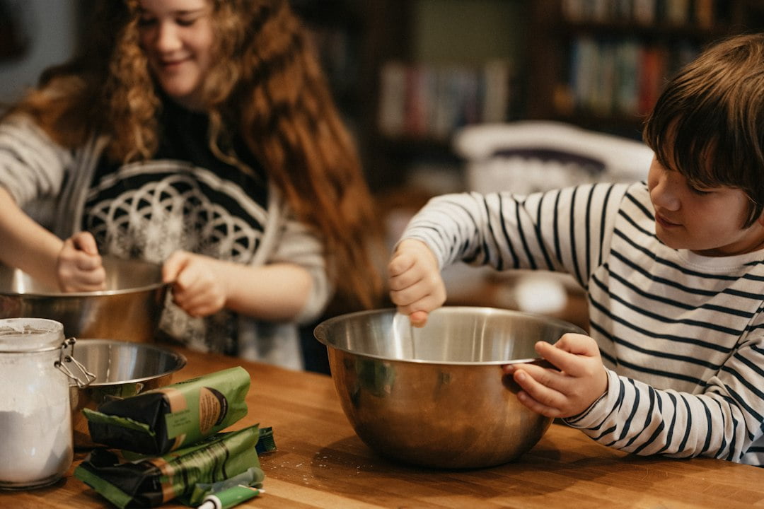 Two children mixing food in bowls.