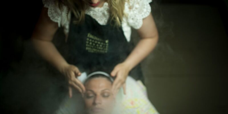 A woman in an apron is getting a steam treatment.