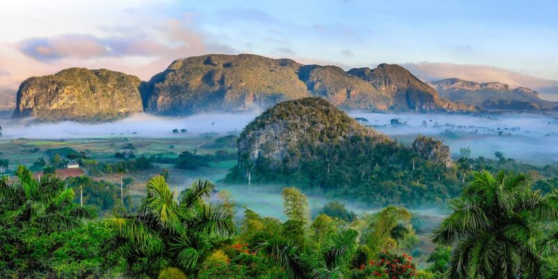 A landscape with mountains and fog.