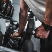 A man lifting dumbbells in a gym.