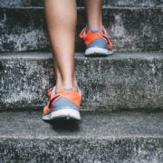 A person's legs and shoes on a concrete staircase.