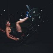 A woman doing a squat on a machine.