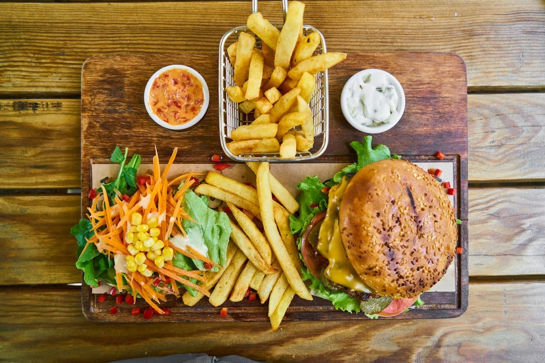 A burger and fries on a wooden surface.