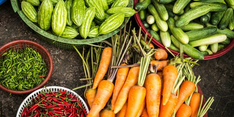 A variety of vegetables in bowls on a table.