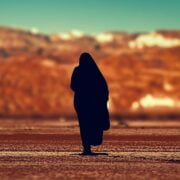 A silhouette of a woman walking in the desert.