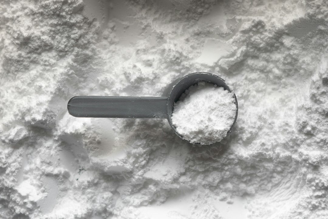 A scoop of white powder on a white surface.