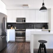 A kitchen with black and white cabinets and stools.