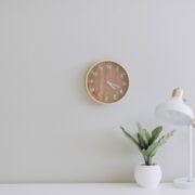 A white desk with a clock on it.