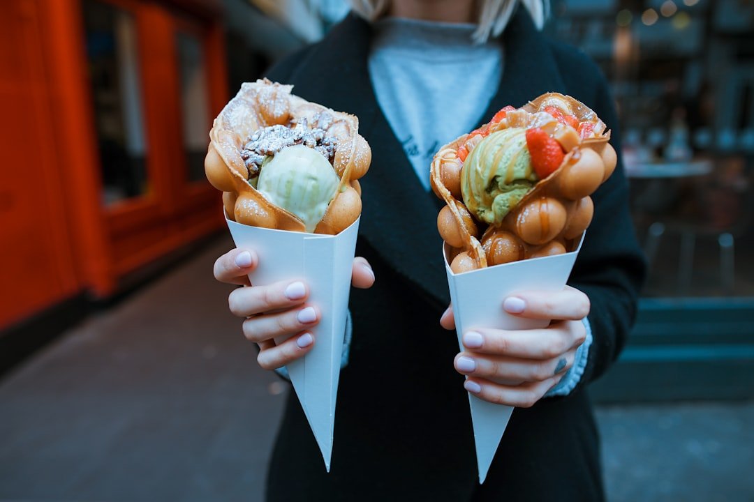 A woman holding two waffle cones.