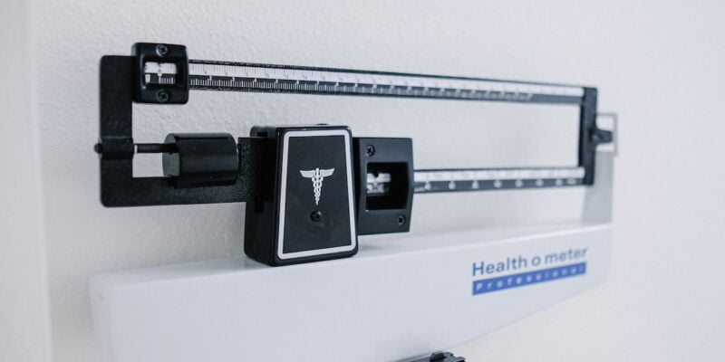 A medical scale hanging on a wall.