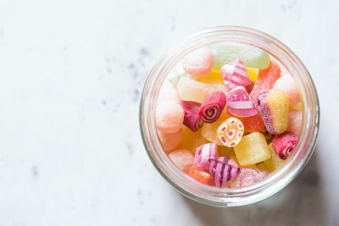 A jar of candy on a marble surface.