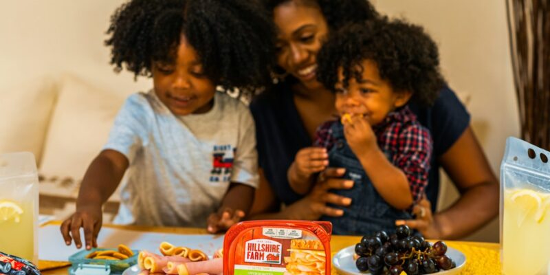 A family sits around a table with food on it.