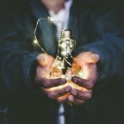 A person holding a light bulb in their hands.