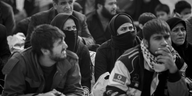 A group of people sitting on the ground.