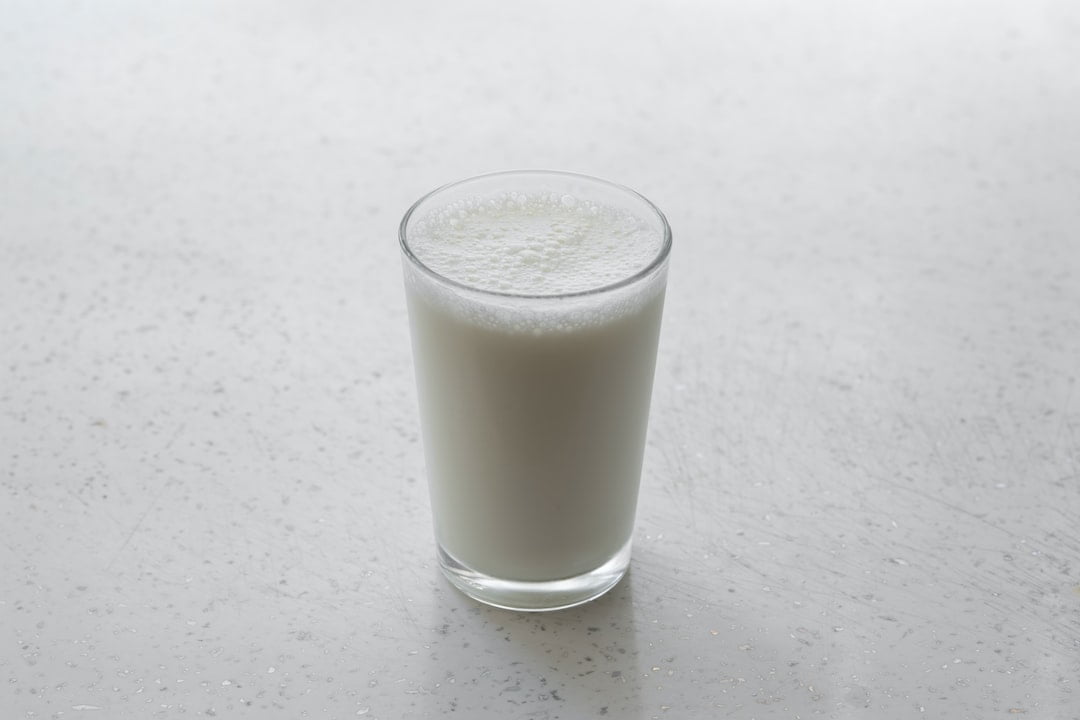 A glass of milk on a counter.