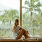 A woman sitting on a window sill.