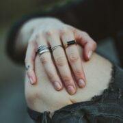 A person's hand with rings on their fingers.