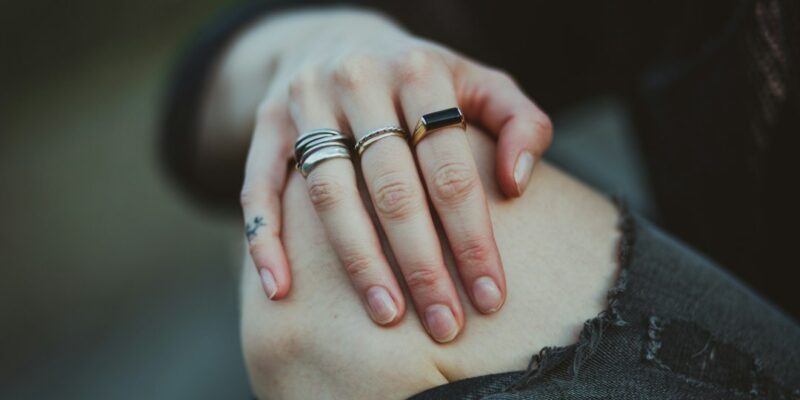 A person's hand with rings on their fingers.