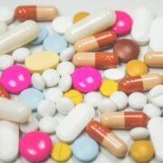 A pile of pills and capsules on a white surface.