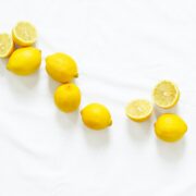 A group of lemons on a white surface.