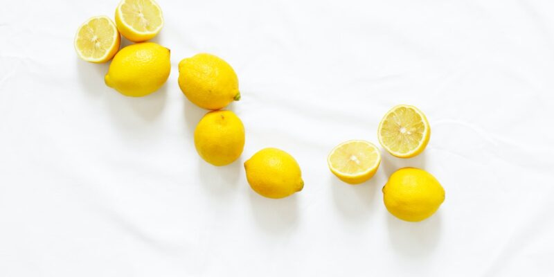 A group of lemons on a white surface.