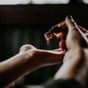 A person's hand holding an essential oil bottle.