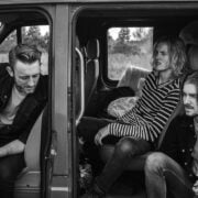 Four men sitting in the back of a van.